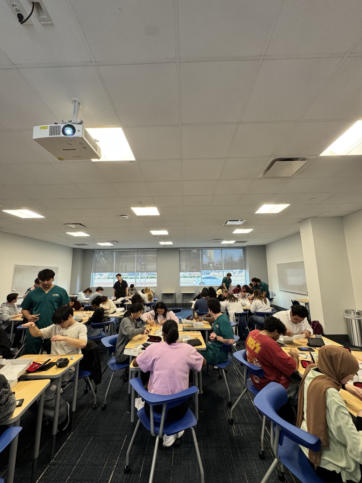 A full classroom of students practicing suturing during the workshop